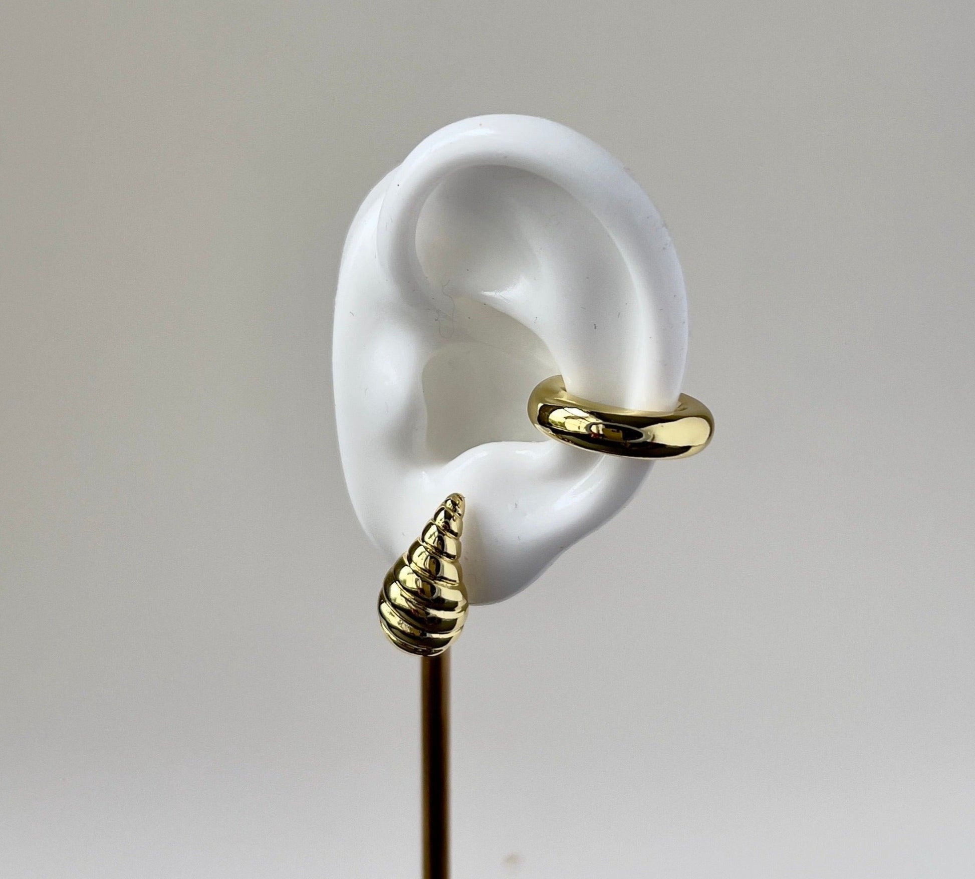 shell shape small gold earring in a silicon ear
