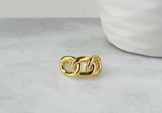 three layers gold ring for women next to white decor