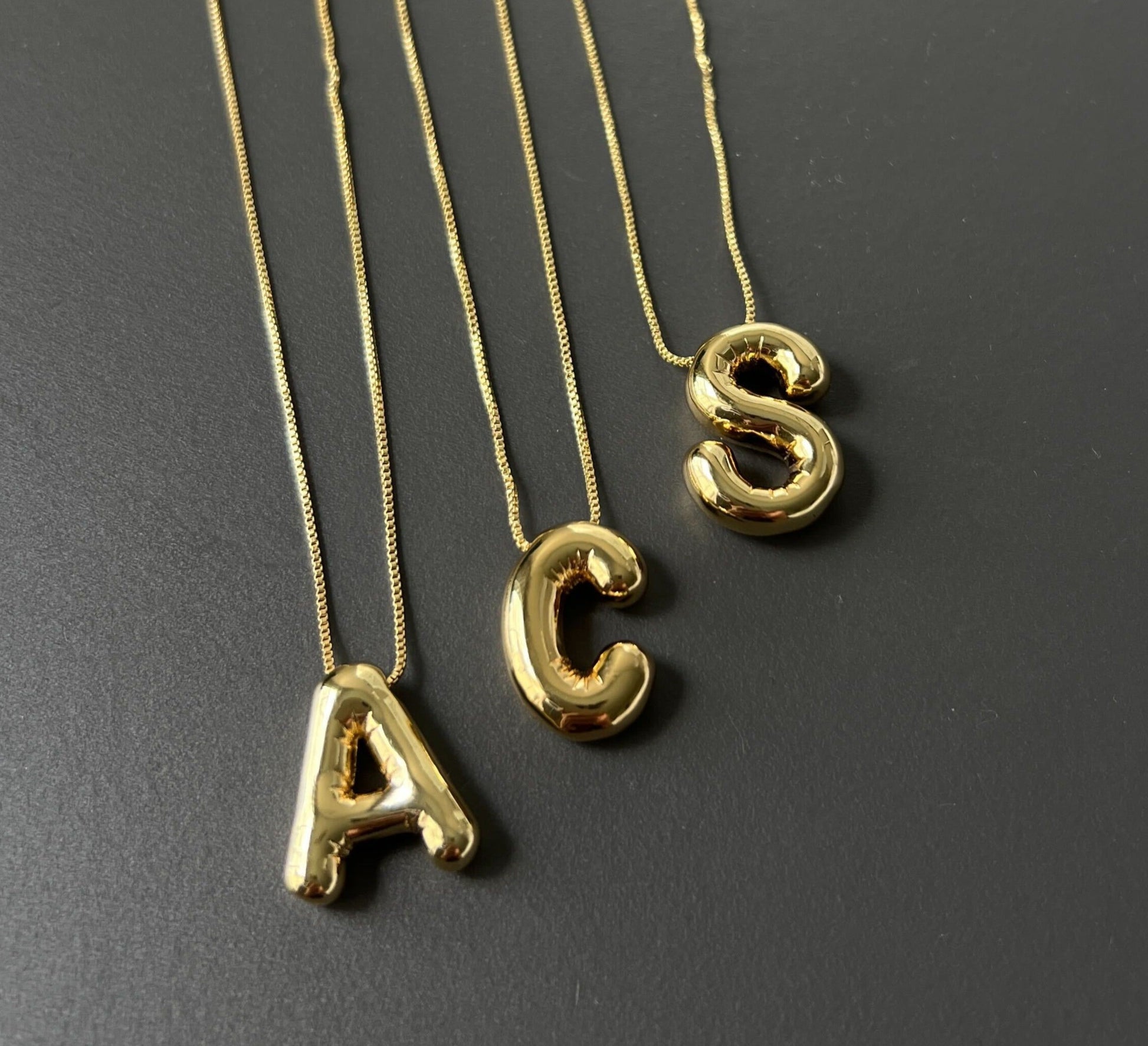 A BUBBLE LETTER NECKLACE IN GOLD