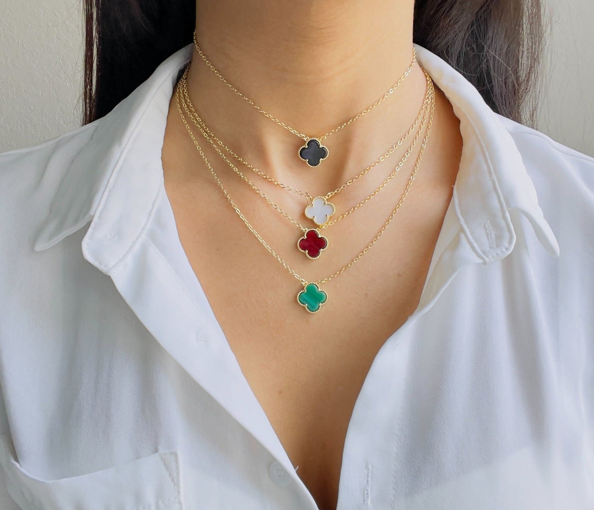 All four leaf clover necklaces in red, black, white and green on a women