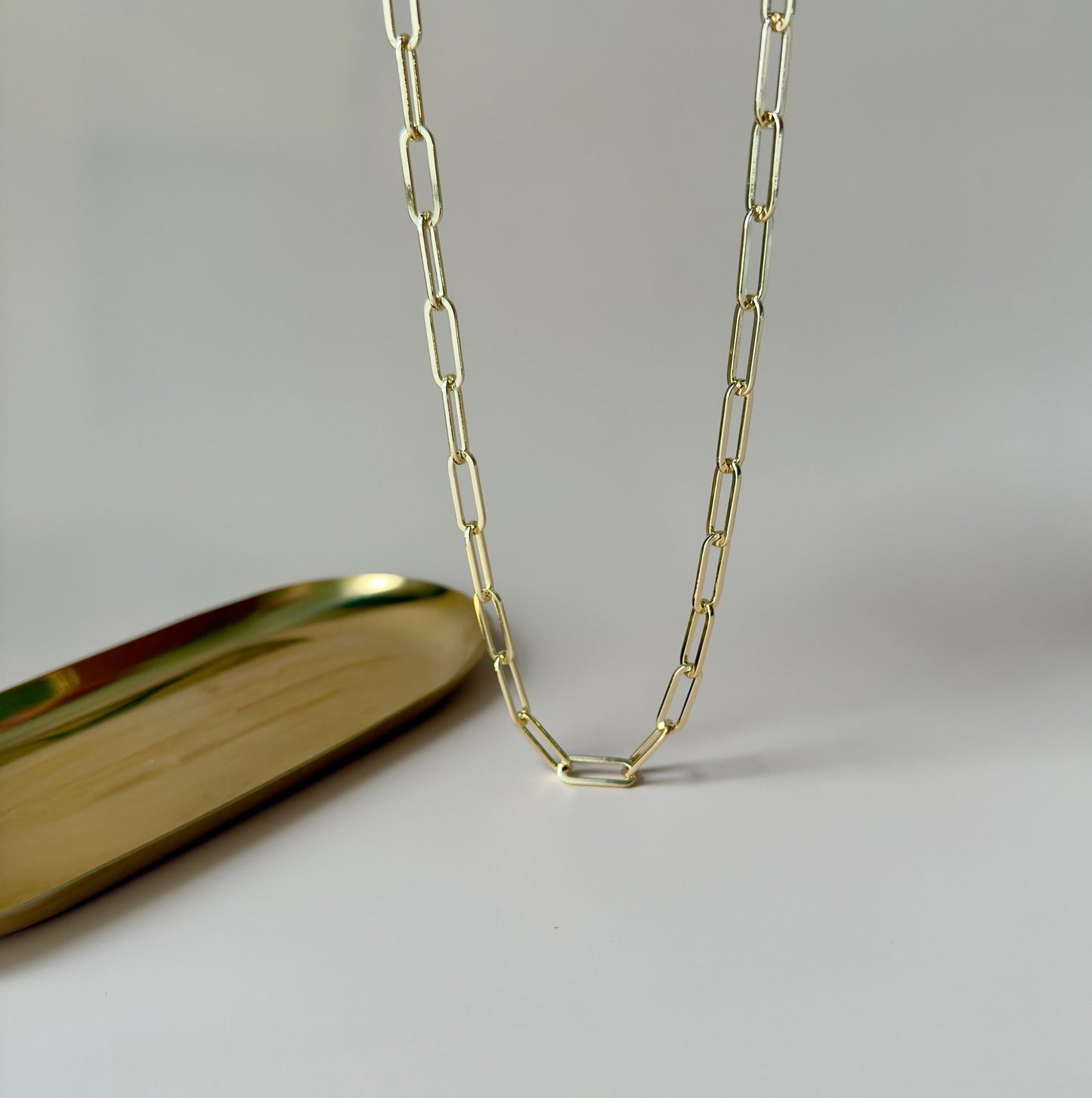 Gold paperclip necklace with modern, interlocking links, highlighting its simplicity and elegance.