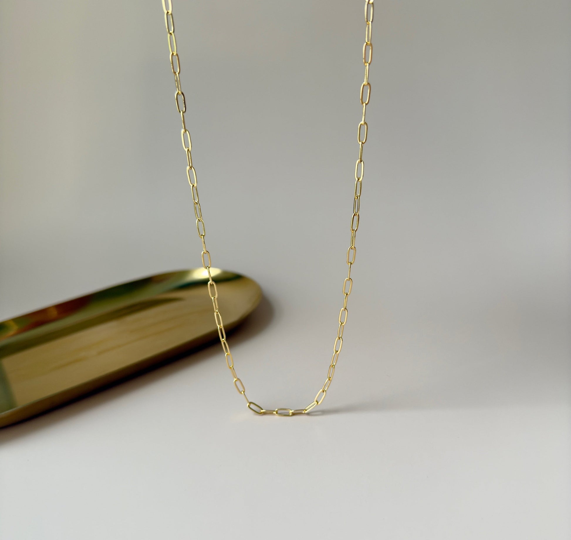 Gold paperclip necklace with modern, interlocking links, highlighting its simplicity and elegance.