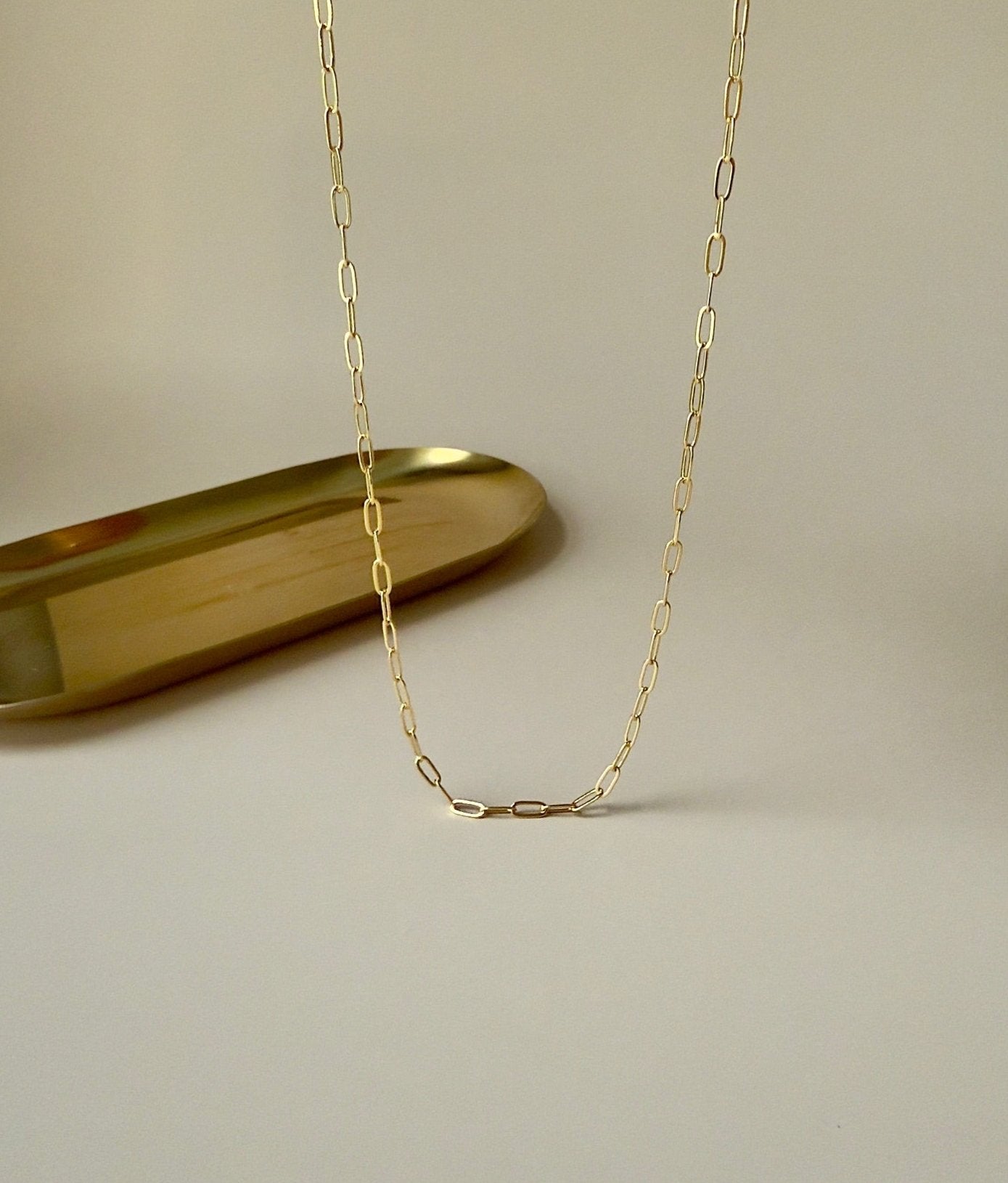 Gold paperclip necklace with modern, interlocking links, highlighting its simplicity and elegance.