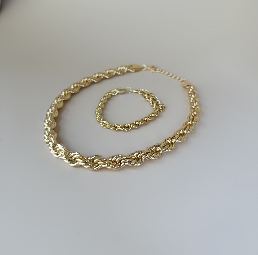 Chunky twisted choker set in gold for women laying flat on a surface