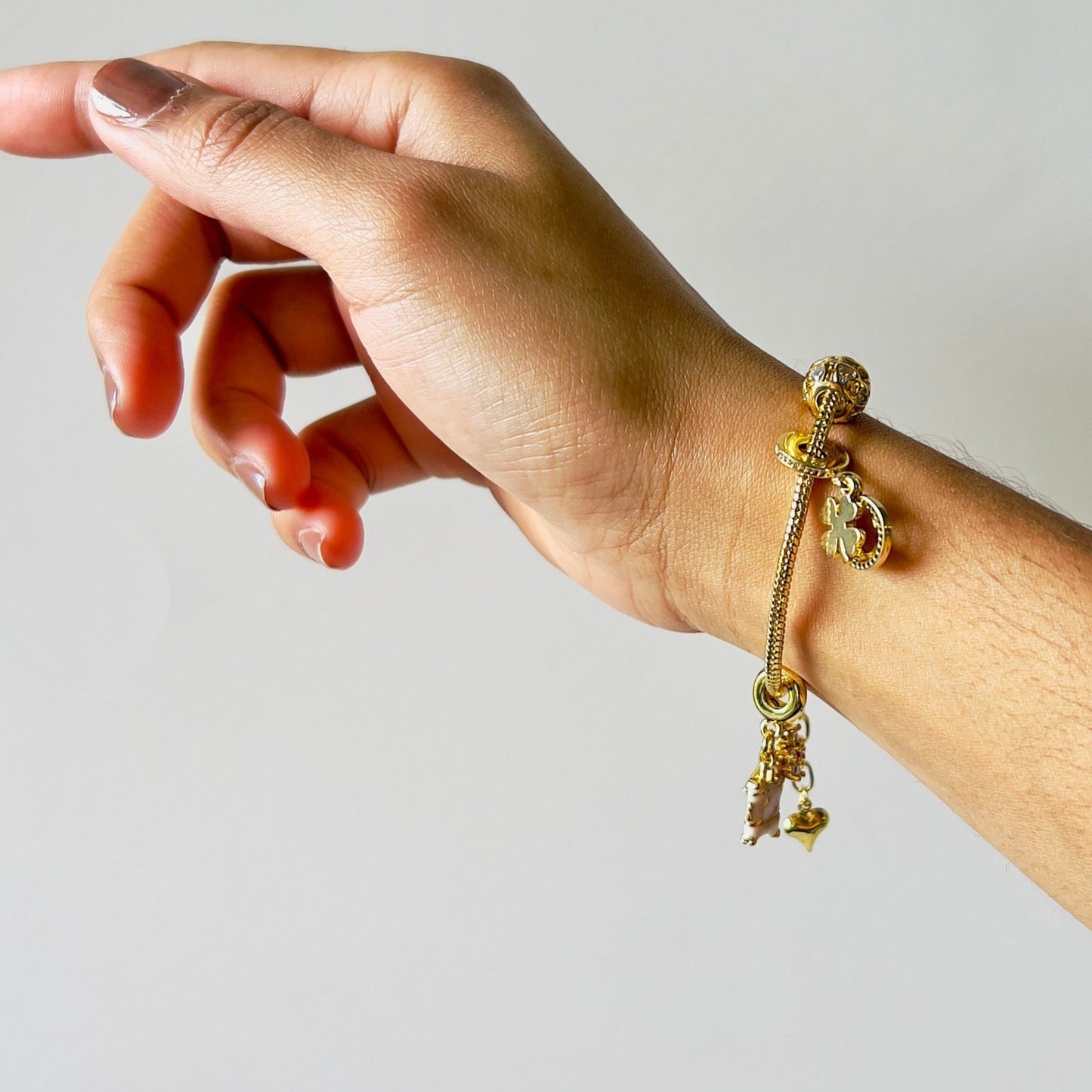charm bracelet in gold in a woman's hand