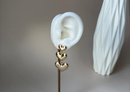 Trio drop earring with heart shape in gold in an earring prop