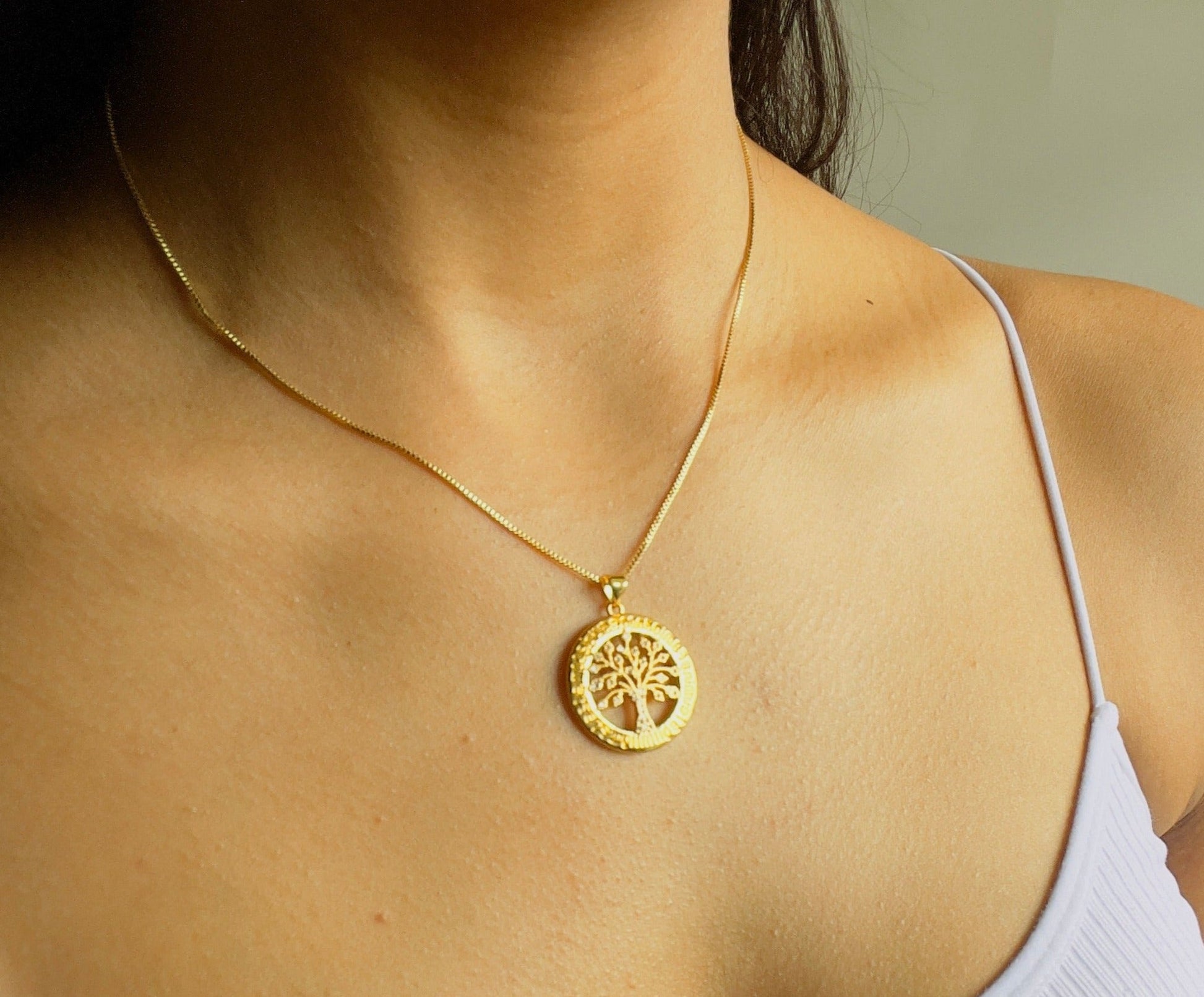 family tree pendant necklace in gold in a woman's neck