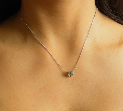 silver heart necklace on woman