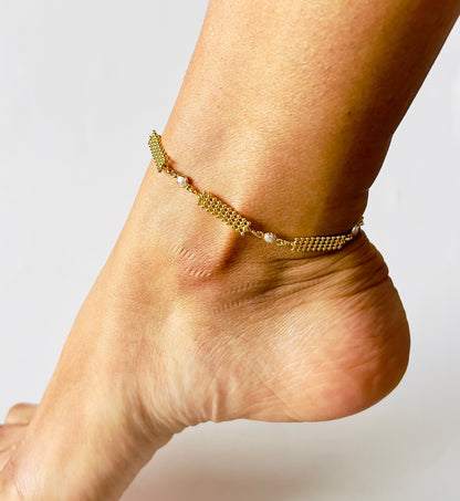 Gold-plated anklet with intricate circle pattern, faux pearl link, and secure lobster clasp