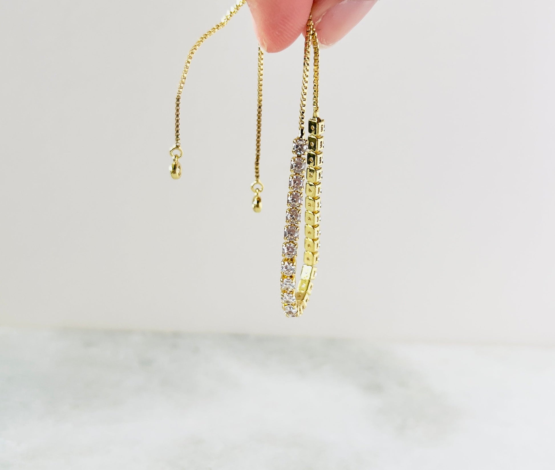 The drawstring is accented with large cubic zirconia stones, enhancing the overall elegance and creating a captivating shimmer with every movement.
